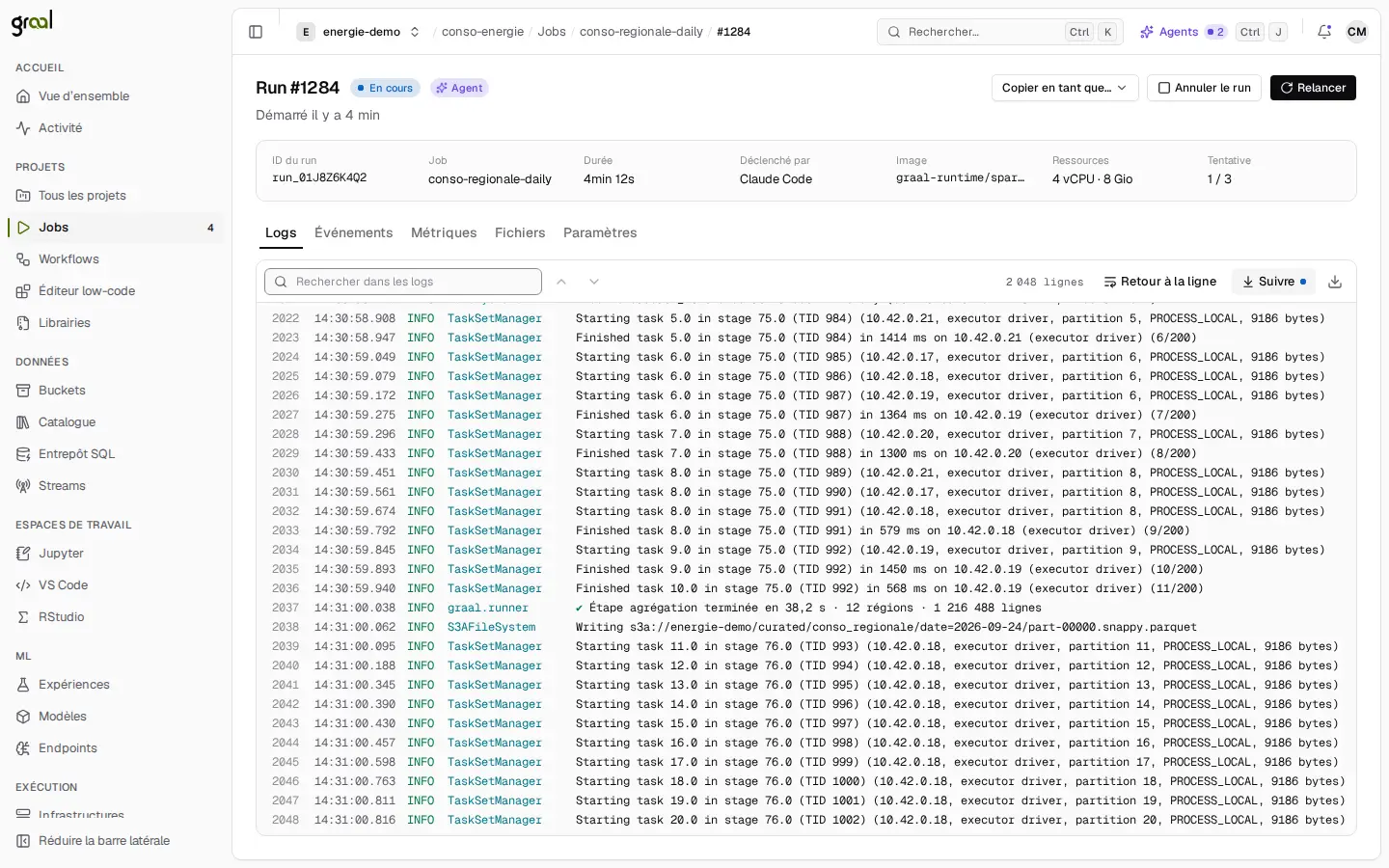Le détail d’un run Spark dans la console graal : statut « En cours », badge « Agent », job conso-regionale-daily déclenché par Claude Code, ressources 4 vCPU et 8 Gio, tentative 1 sur 3, et le journal qui défile ligne à ligne avec l’écriture d’un fichier Parquet sur S3.