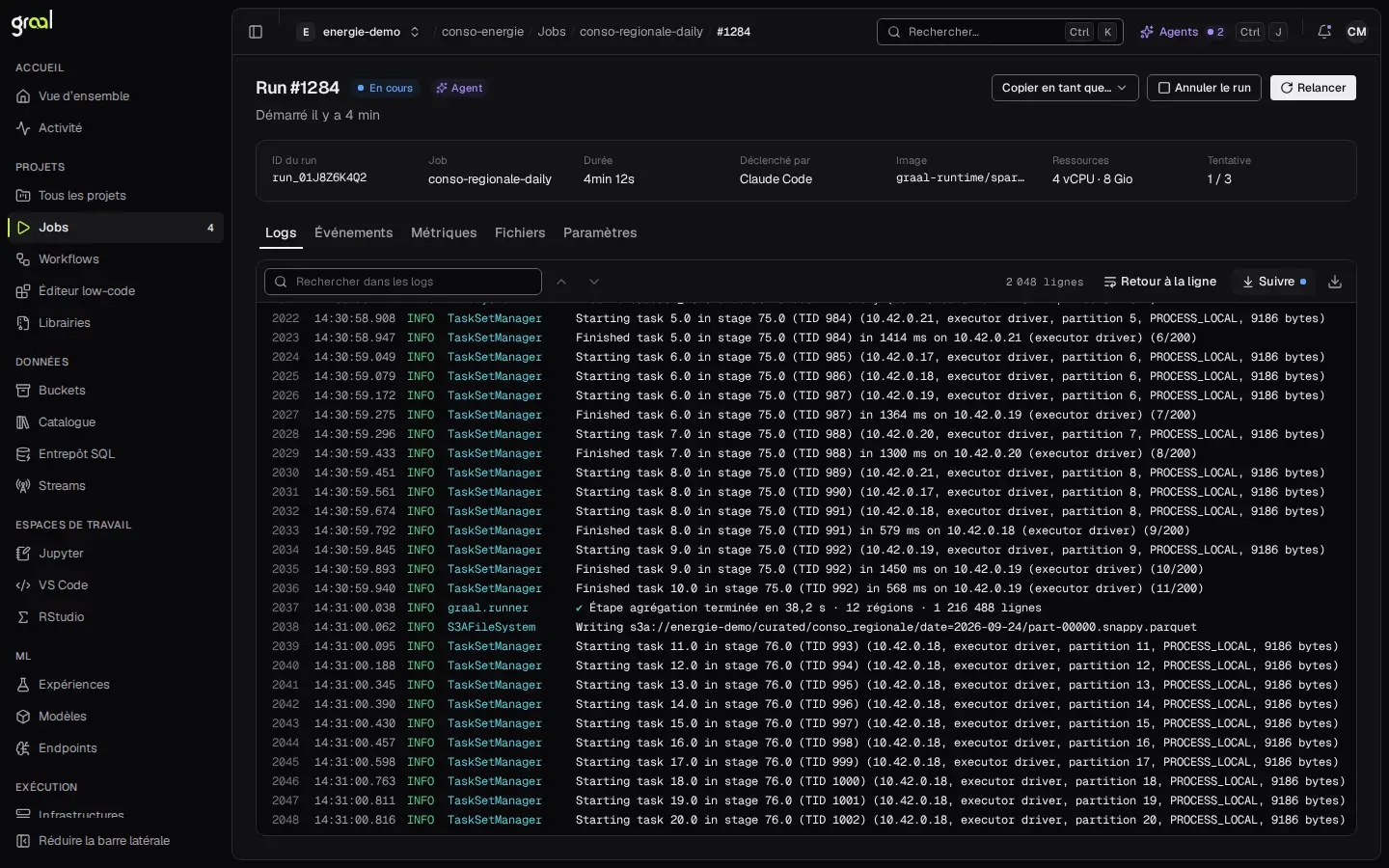 Le détail d’un run Spark dans la console graal : statut « En cours », badge « Agent », job conso-regionale-daily déclenché par Claude Code, ressources 4 vCPU et 8 Gio, tentative 1 sur 3, et le journal qui défile ligne à ligne avec l’écriture d’un fichier Parquet sur S3.